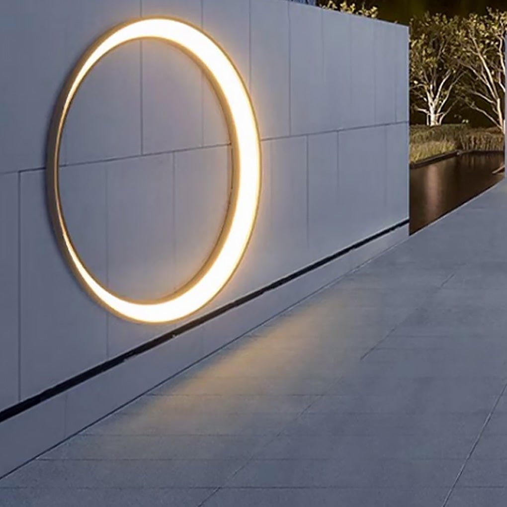 Outdoor cylinder wall light installed along a long exterior wall, guiding movement with soft circular illumination at night.