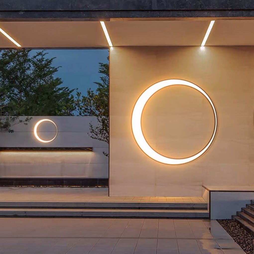 Outdoor cylinder wall light featured on a contemporary building facade with layered walls and subtle ambient lighting.