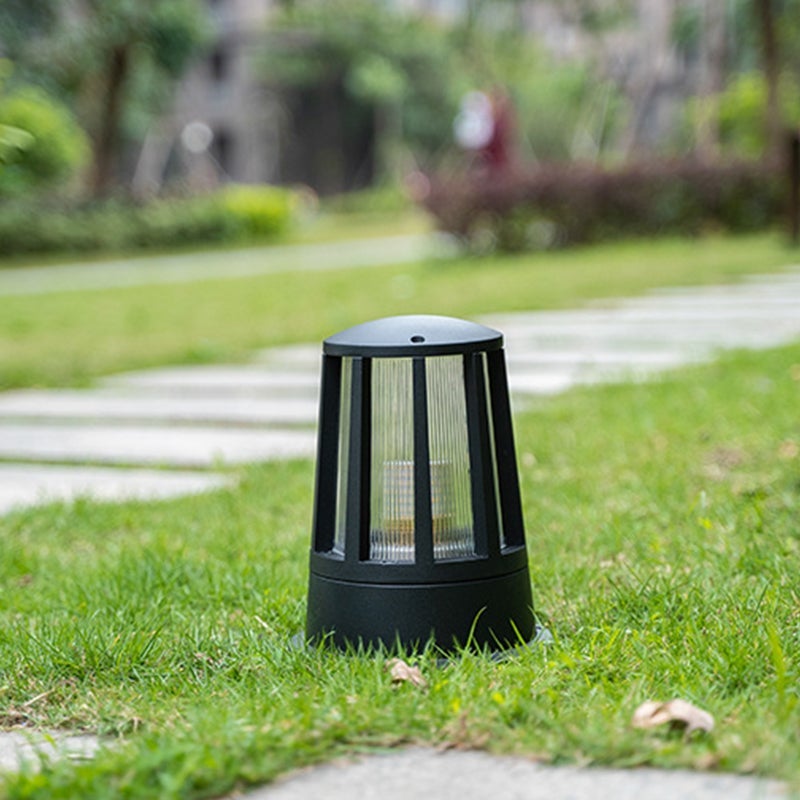 Outdoor garden path lamp providing soft illumination along a brick pathway.