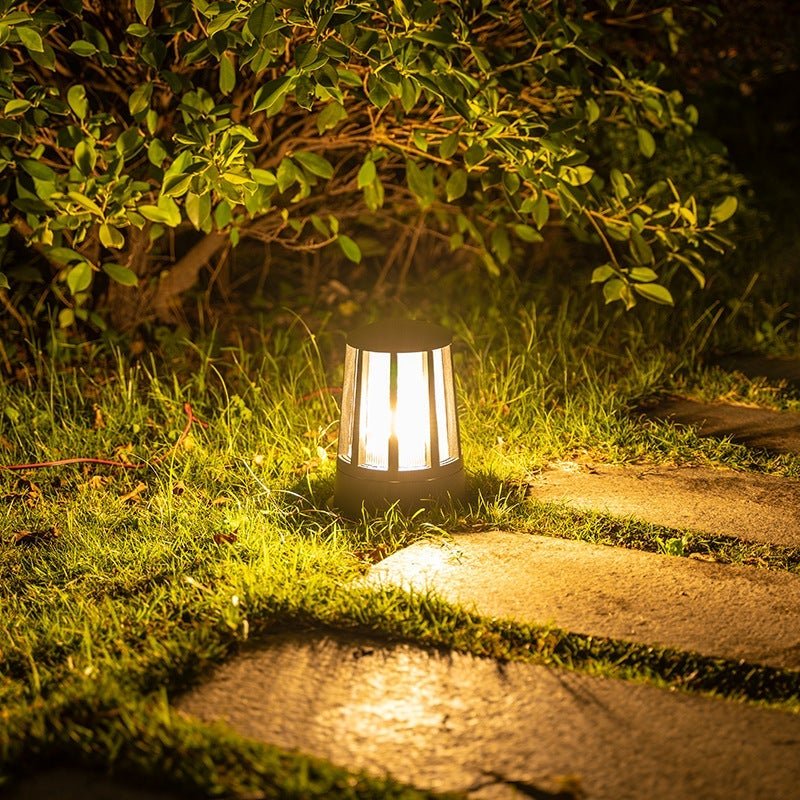 Outdoor garden path lamp with a close-up of its illuminated ribbed glass design.