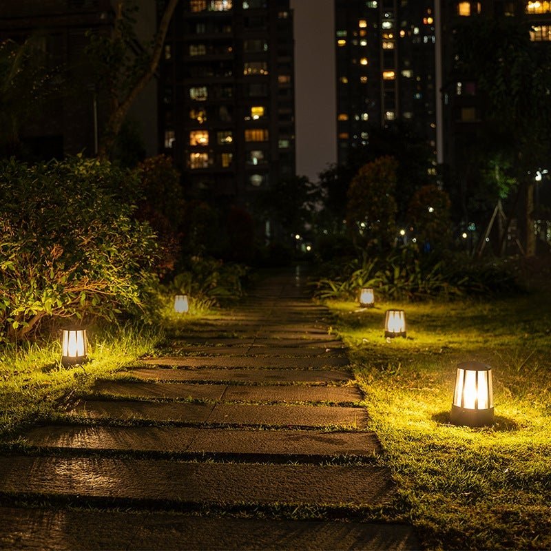 Outdoor garden path lamp with a close-up of its sleek black and ribbed glass structure.