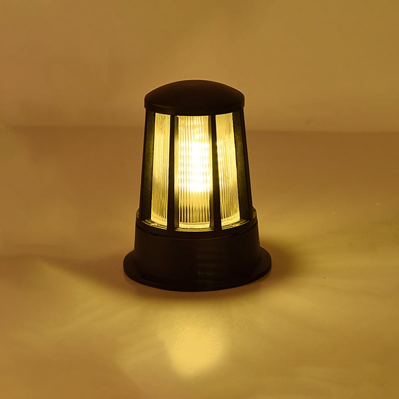 Outdoor garden path lamp illuminating a grassy lawn with warm light.