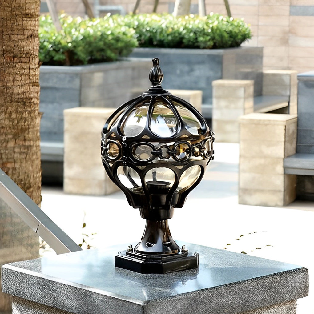 Close-up of outdoor globe pillar lights, showcasing the detailed gold lattice pattern and ornate finial.