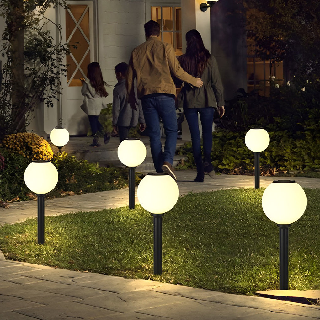 Outdoor path light globe illuminating a minimalist outdoor walkway with focused glow.