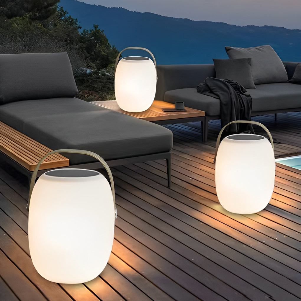Outdoor solar floor lanterns on beach sand with serene ocean background.