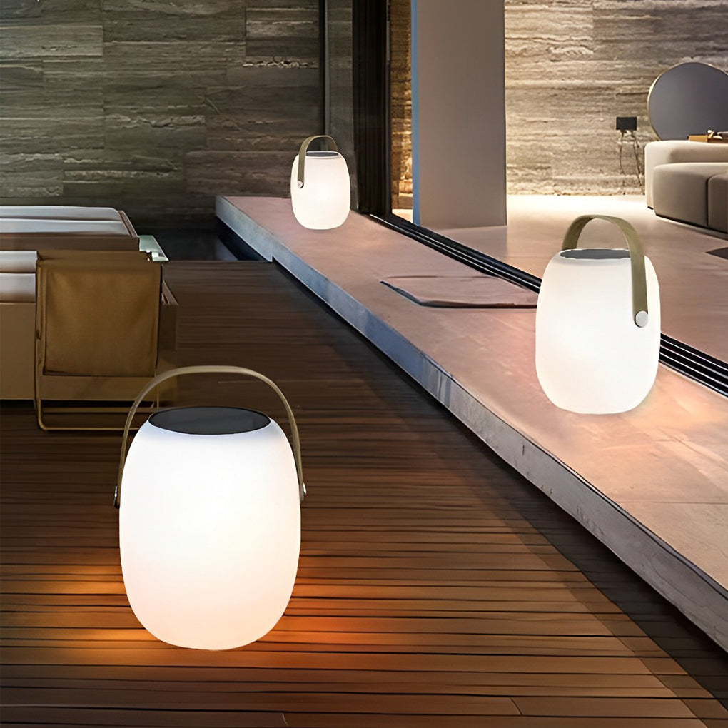 Outdoor solar floor lanterns hanging from tree branch with warm light.