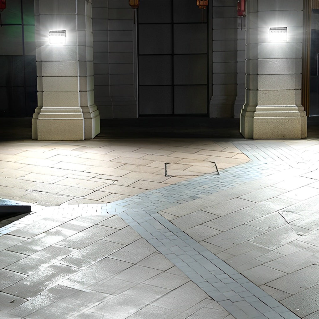 Outdoor solar wall light with motion sensor providing warm light beside a brick wall.