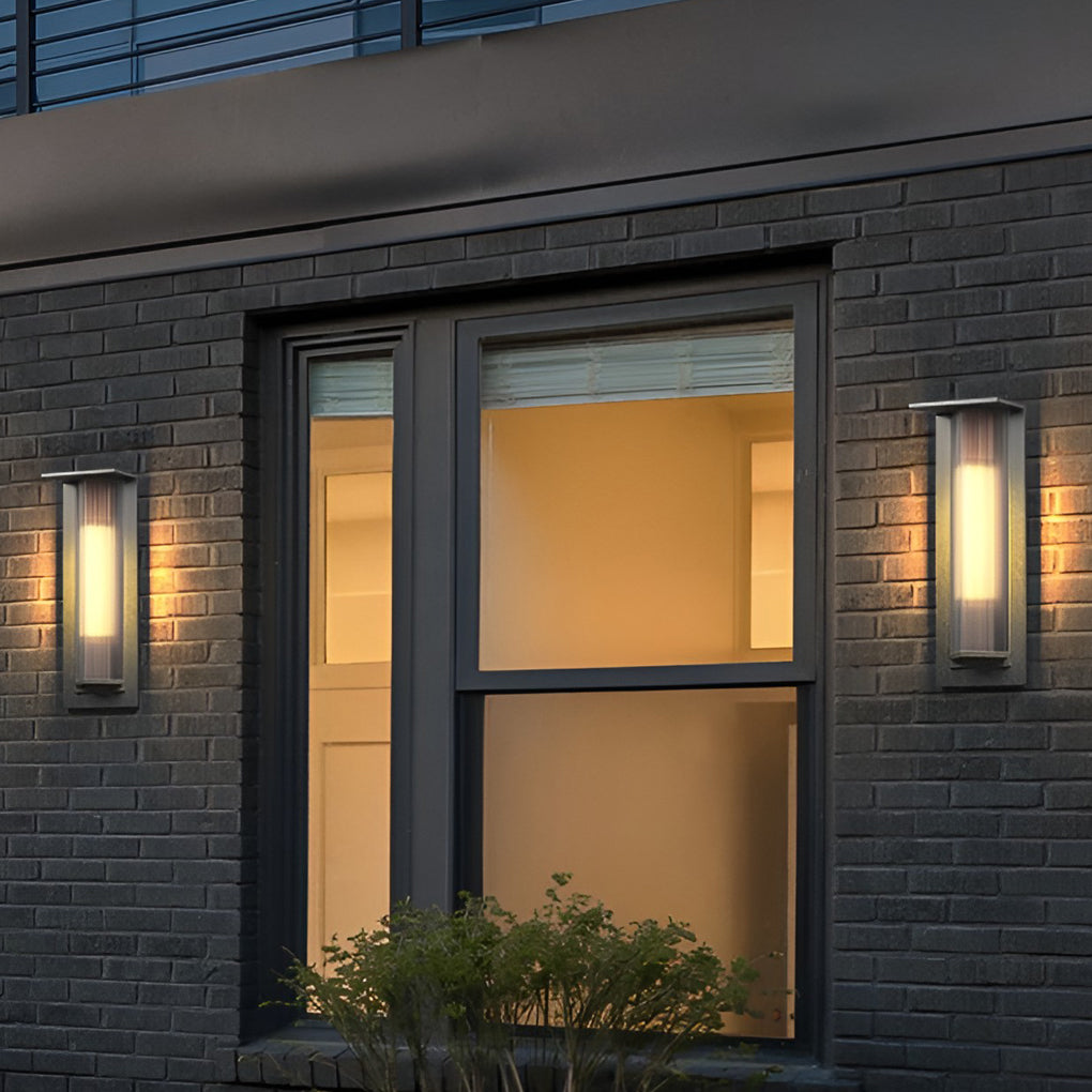 Outdoor vertical wall sconce enhancing a modern outdoor seating area with warm light.