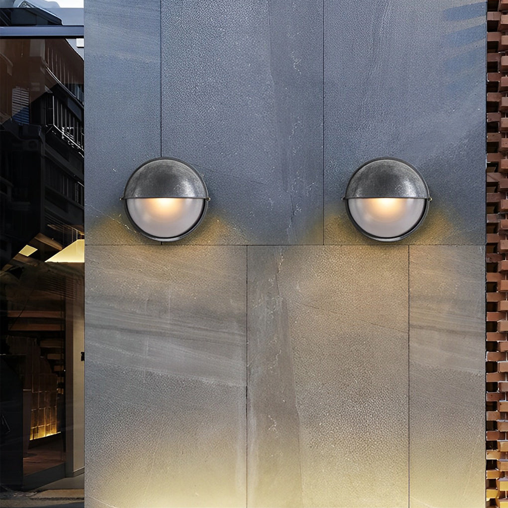 Pair of compact oval bulkhead wall lights installed symmetrically on a concrete exterior surface.