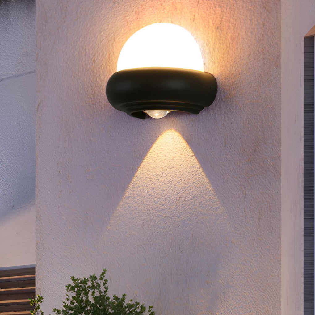 Pair of modern globe wall sconces in black, illuminating a minimalist outdoor space.