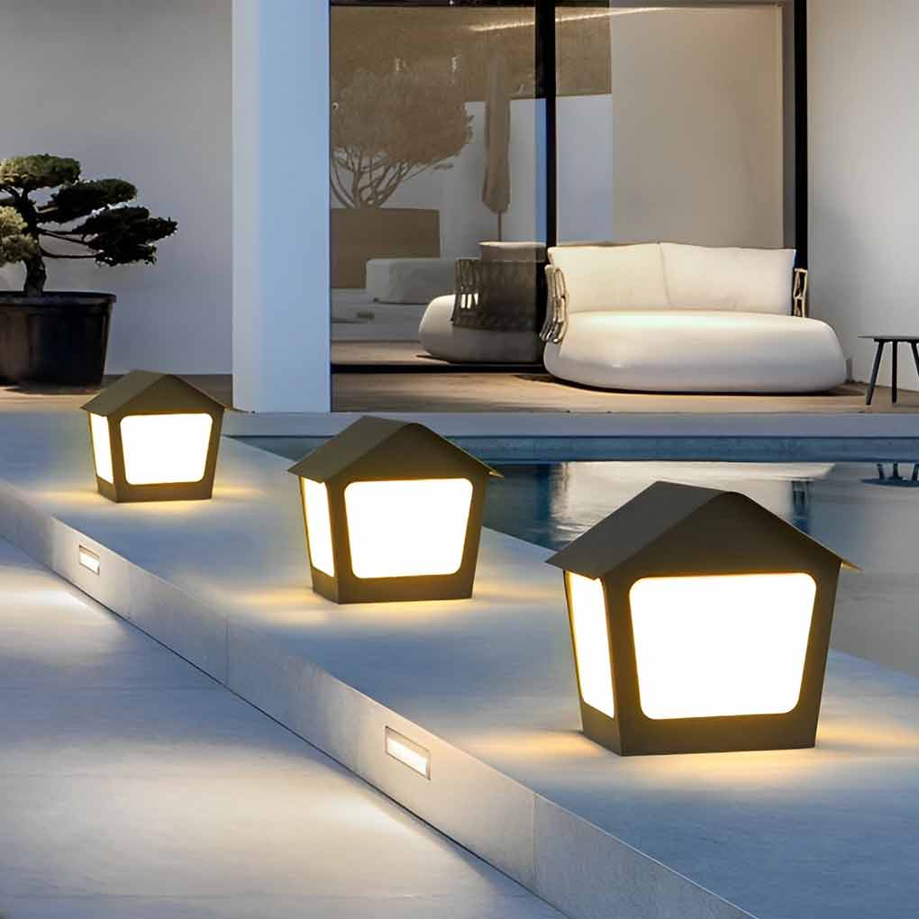 Patio pillar lights with close-up of its house-shaped design and light output.