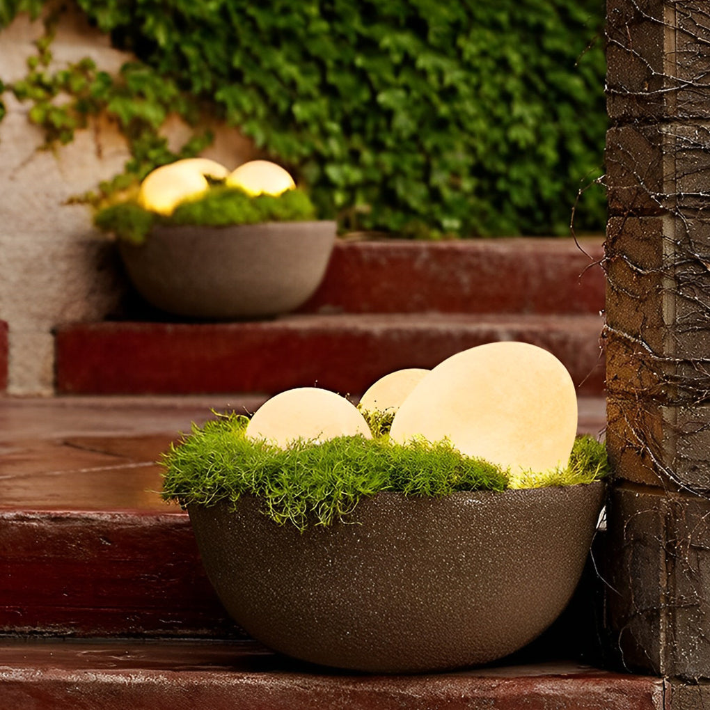 Pebble garden lights providing soft illumination for a contemporary landscape.