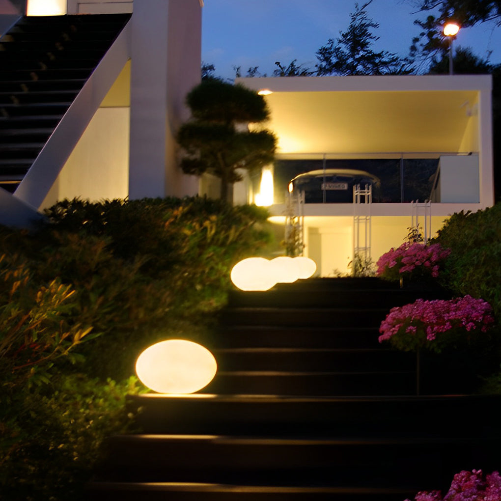 Pebble garden lights illuminating a cozy outdoor staircase with ambient light.