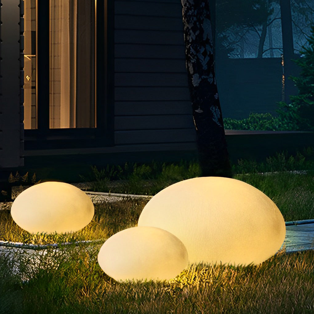Pebble garden lights with detailed view of their textured surface.