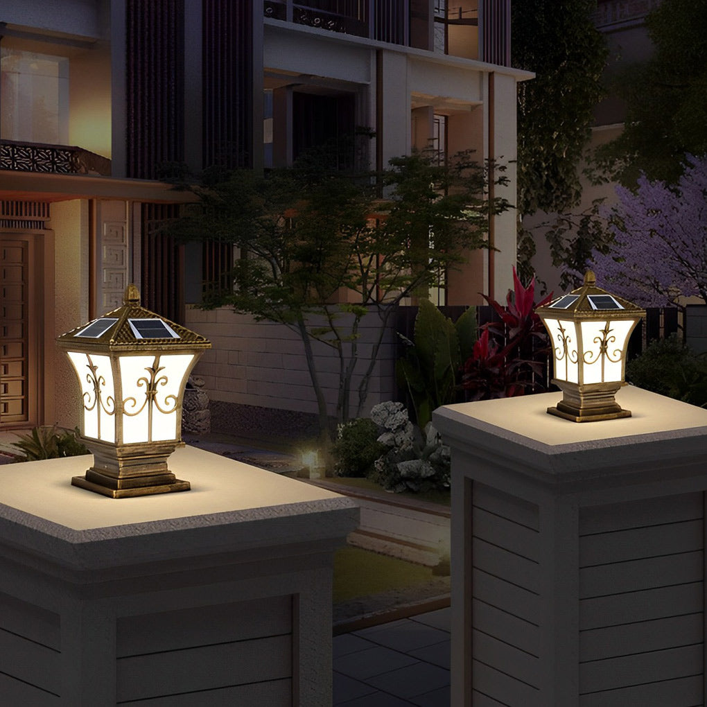 Pillar lantern lights with intricate patterns, glowing softly in a garden setting.
