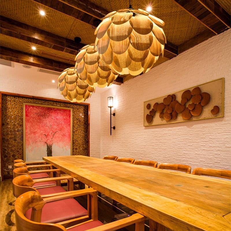 Pinecone pendant light with a natural finish, hanging above a wooden dining table.