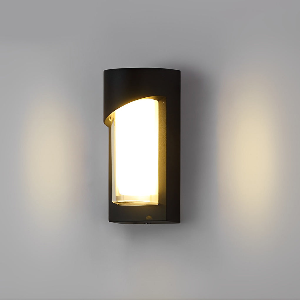 Black outdoor wall light with rectangular shape on gray wall near outdoor furniture.