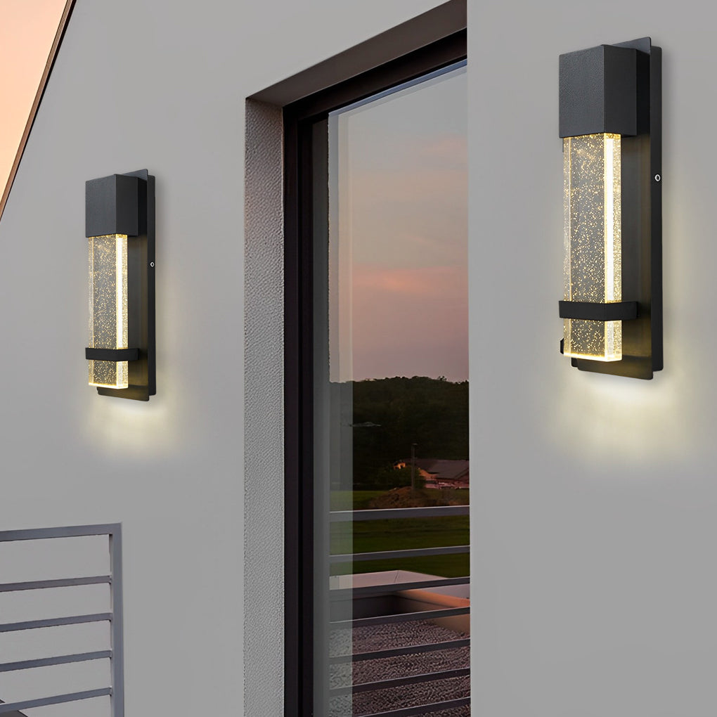 Modern rectangular outdoor wall lights with black finish installed beside exterior doorway with warm ambient glow.