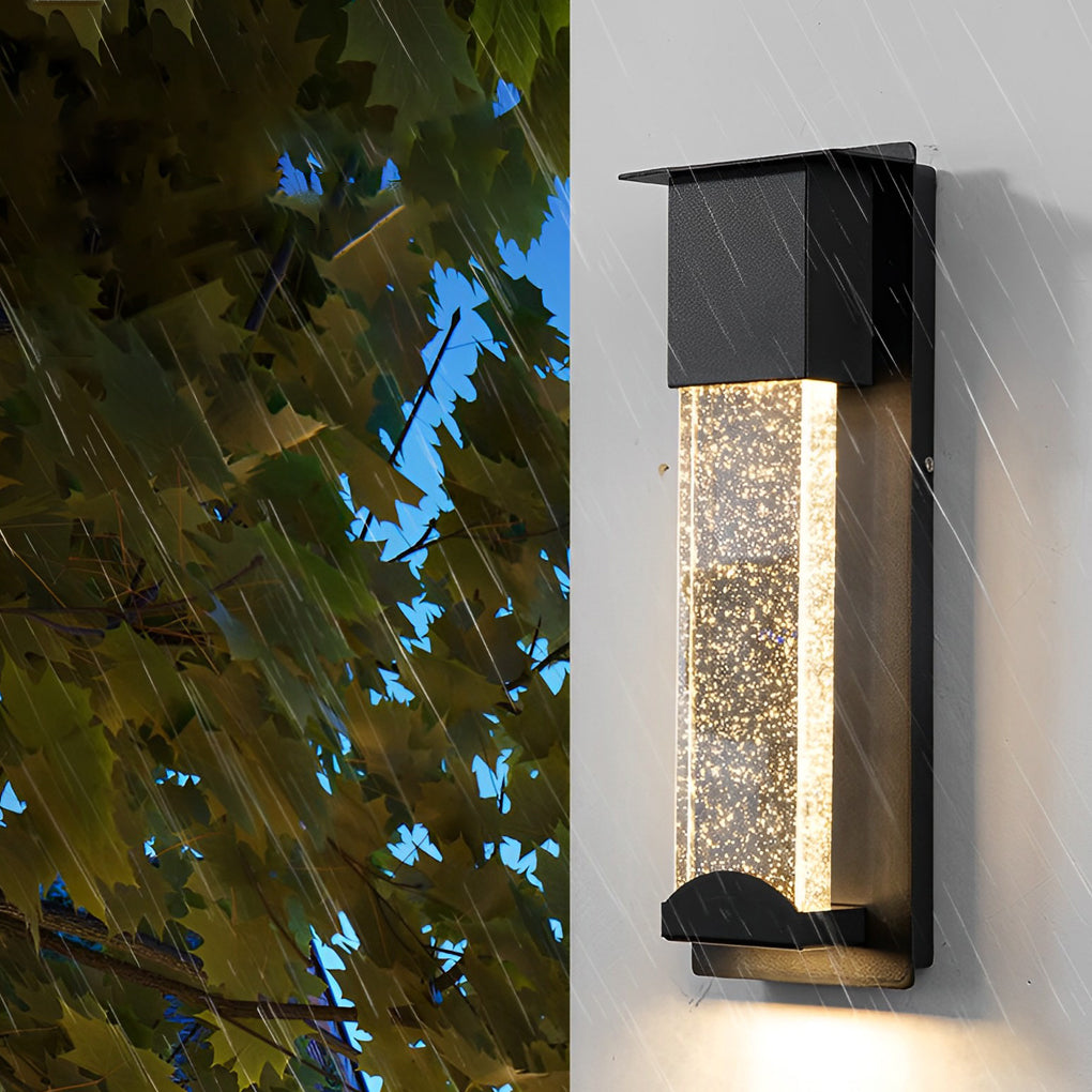 Black rectangular outdoor wall lights with bubble glass design mounted on exterior wall near trees.