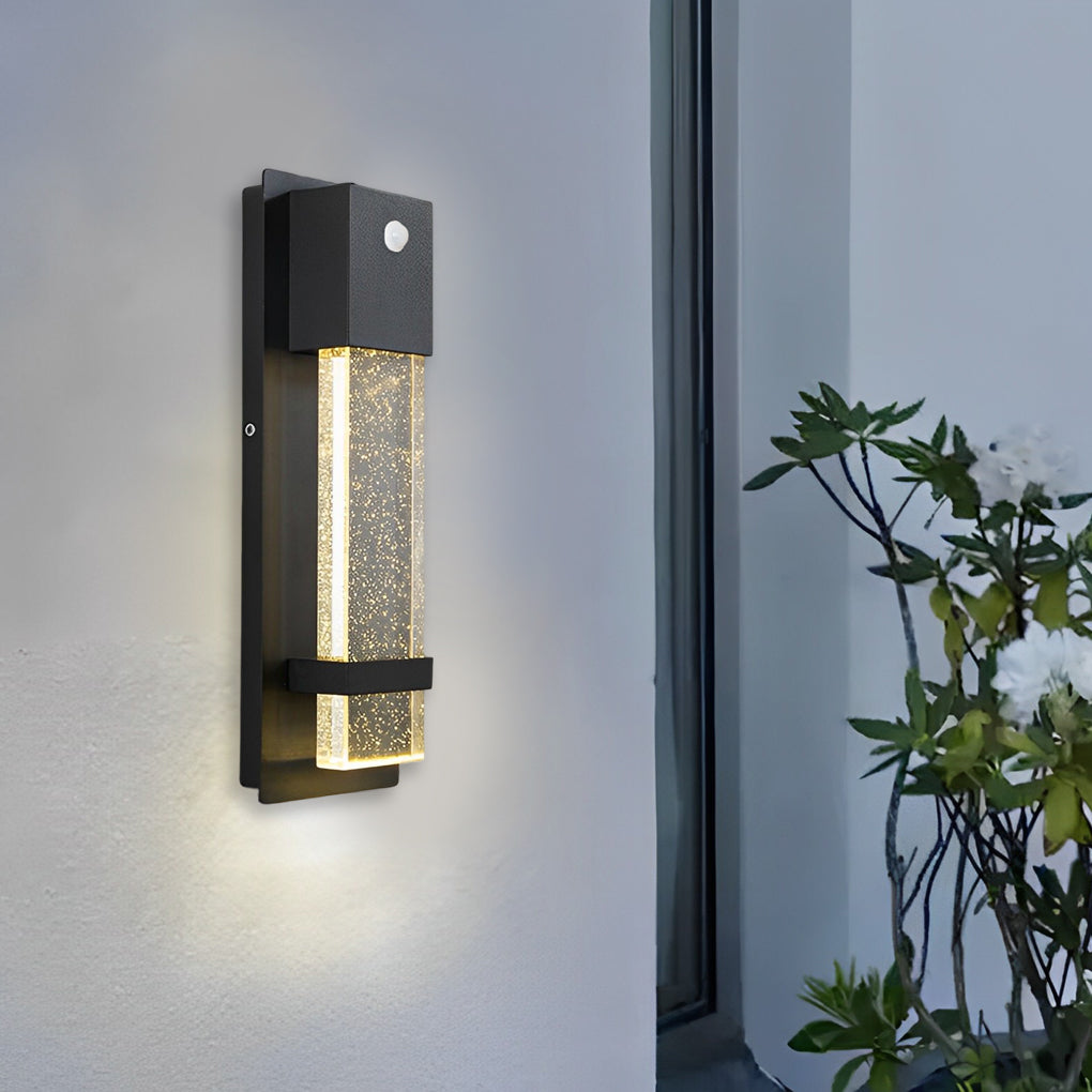Slim rectangular outdoor wall lights with textured glass mounted on exterior wall near window.