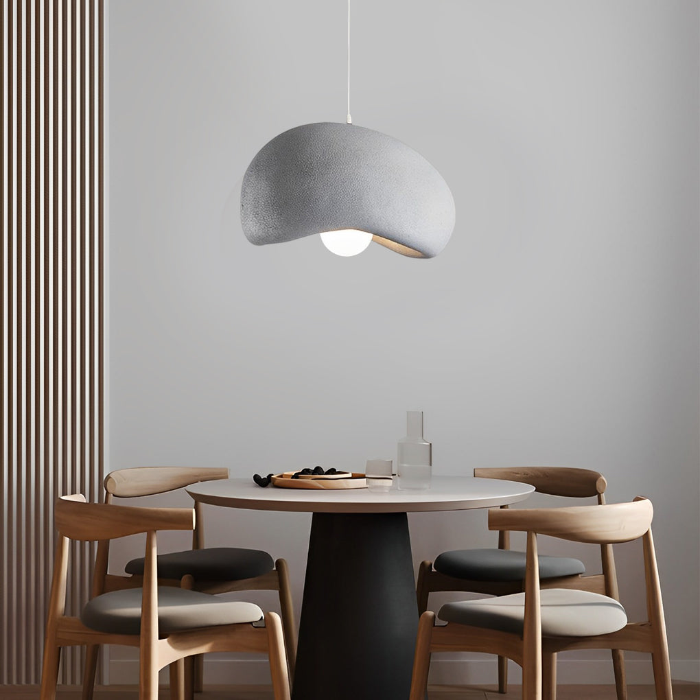 Resin pendant light with a textured finish, providing warm illumination in a stylish dining space.