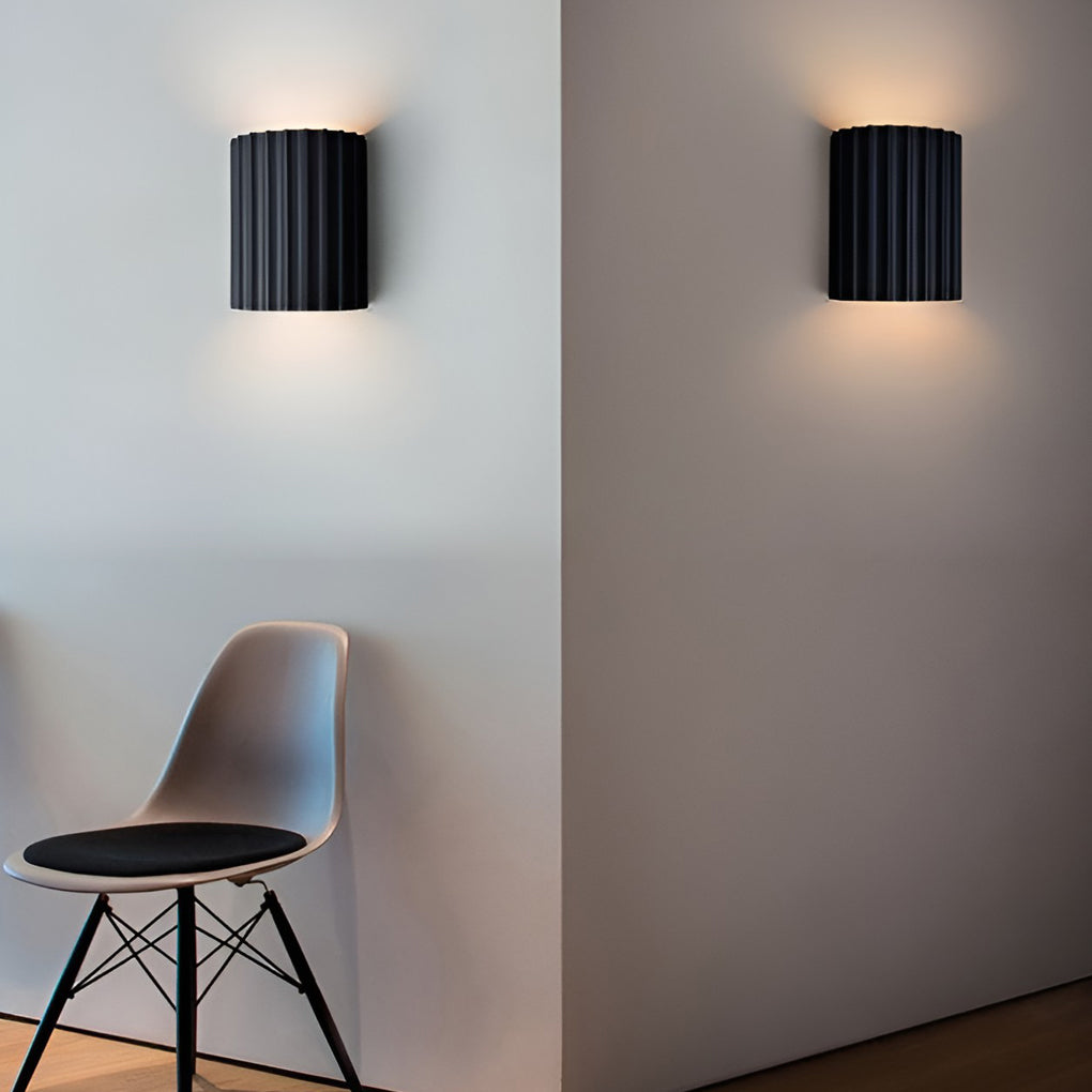 Ribbed wall sconces illuminating a minimalist interior with focused glow.