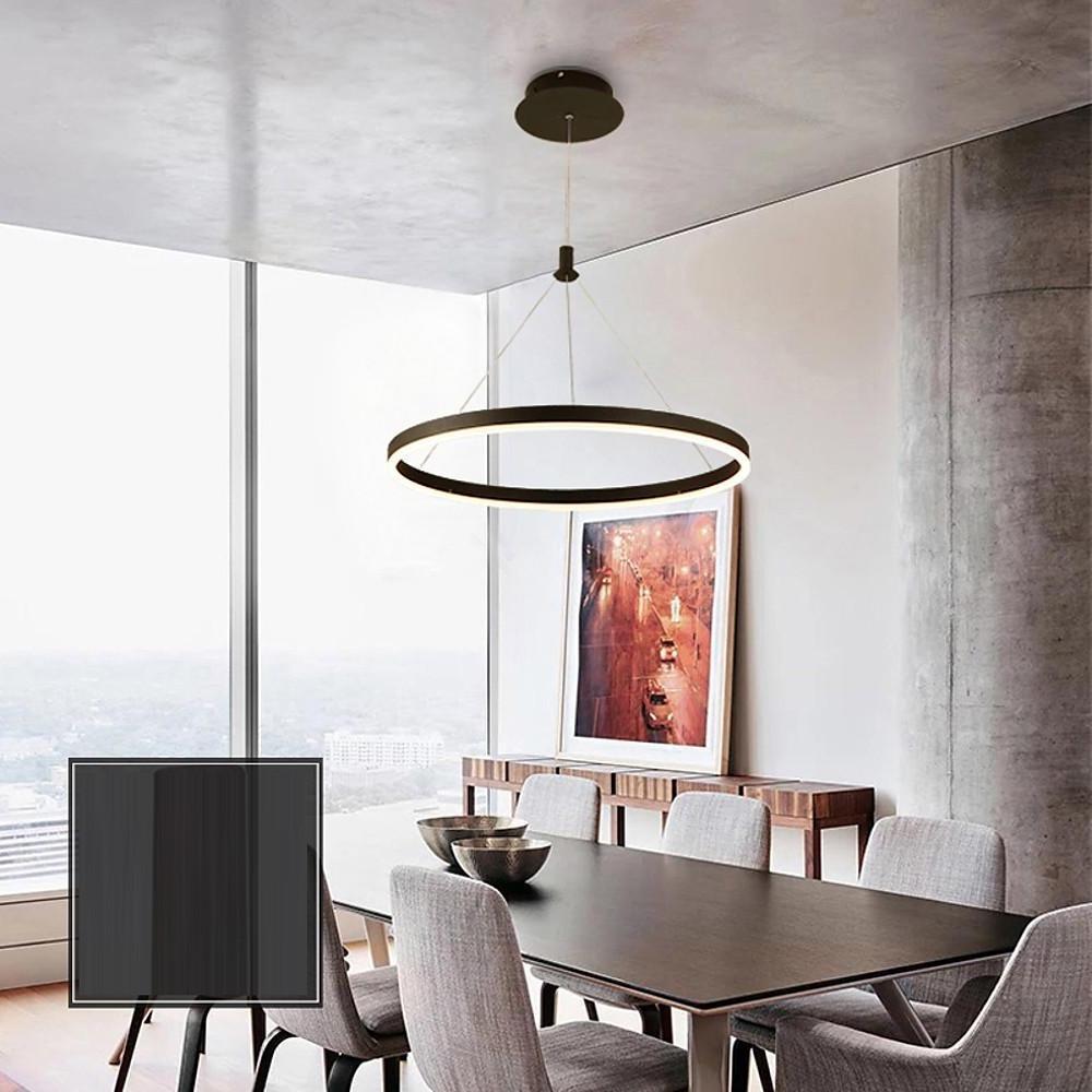 Ring metal chandelier hanging above a dining table in a modern apartment interior with warm ambient lighting.