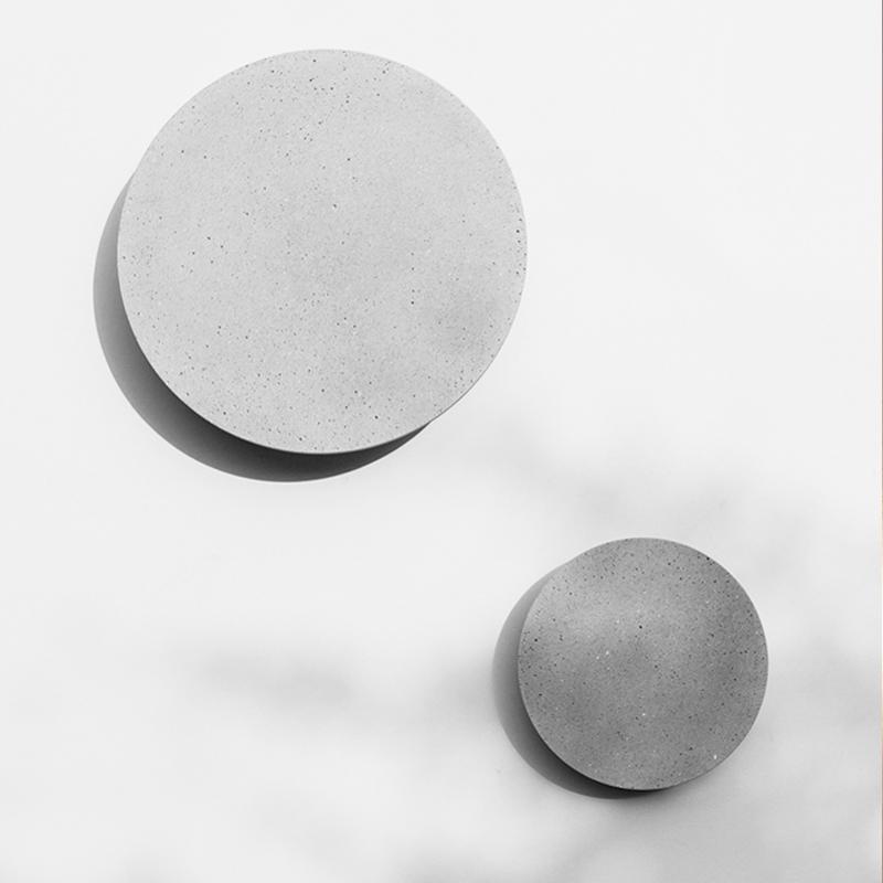 Round exterior wall lights with a sleek design, illuminating a stylish outdoor area.