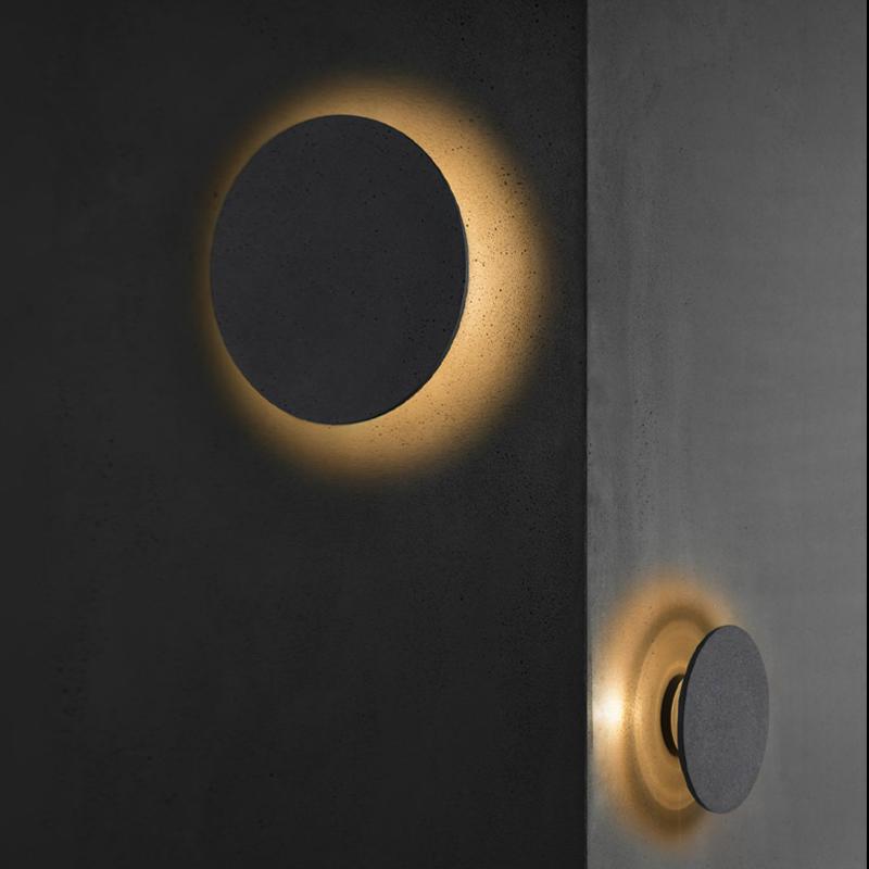 Round exterior wall lights providing soft illumination on a modern exterior wall.
