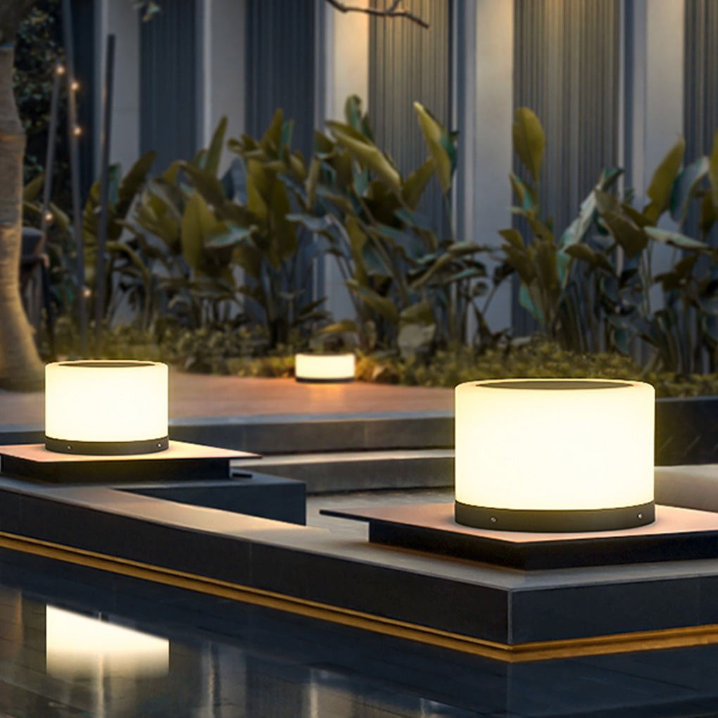 Round pillar lights illuminating a garden pillar with greenery.