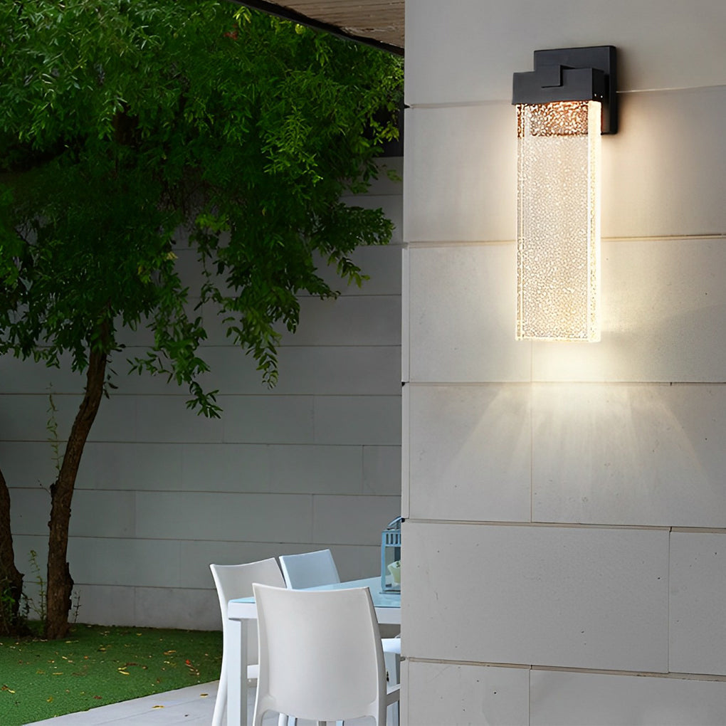 Seeded glass outdoor wall lighting near a tree, providing warm light for an outdoor space.