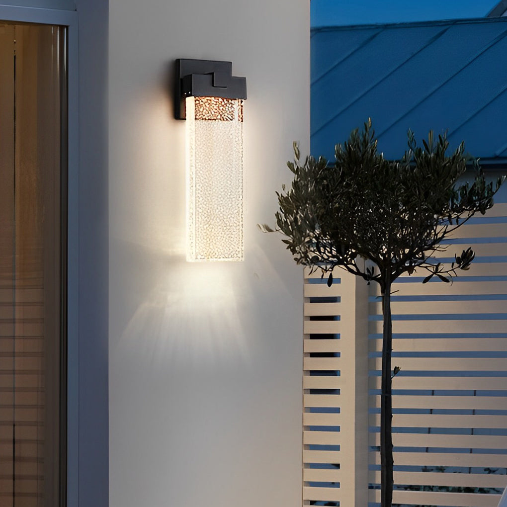 Seeded glass outdoor wall lighting mounted on a white wall, creating a cozy ambiance.