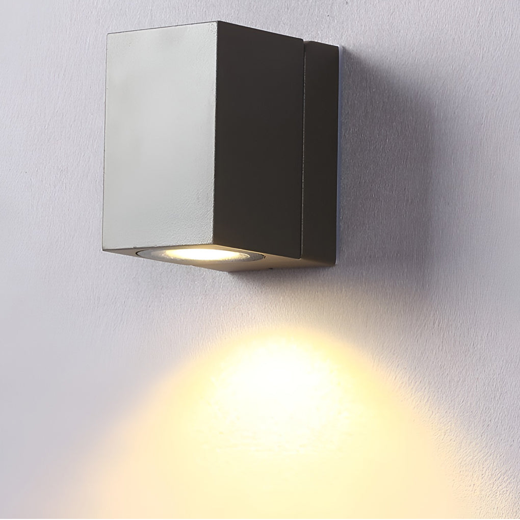 Outdoor sensor wall lights in black, mounted on a white wall, casting downward light.