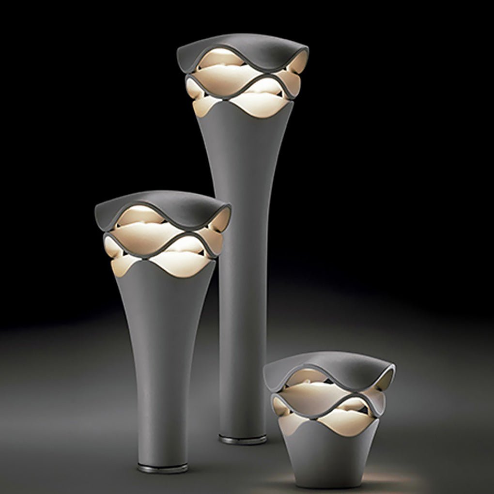 Set of three wave design path lights in various heights on a dark studio background for garden