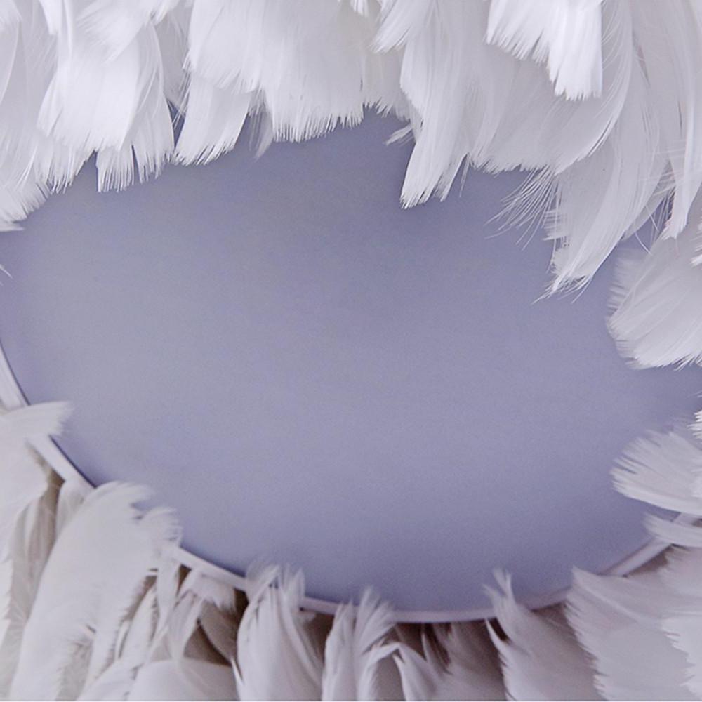 Side profile image showing rounded volume of a feathered fluffy hanging light fixture.