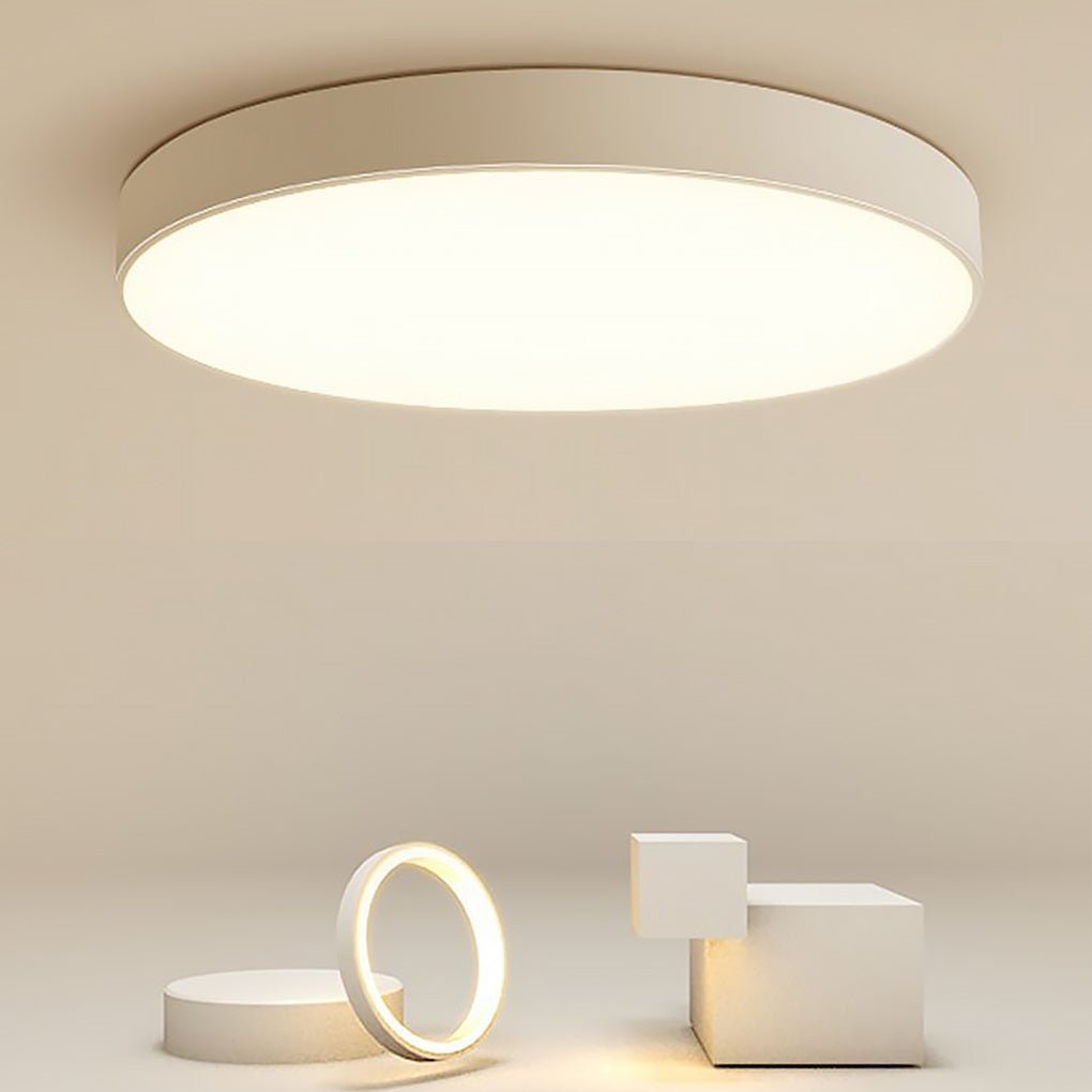 Simple flush mount ceiling light emitting warm white light in clean interior.