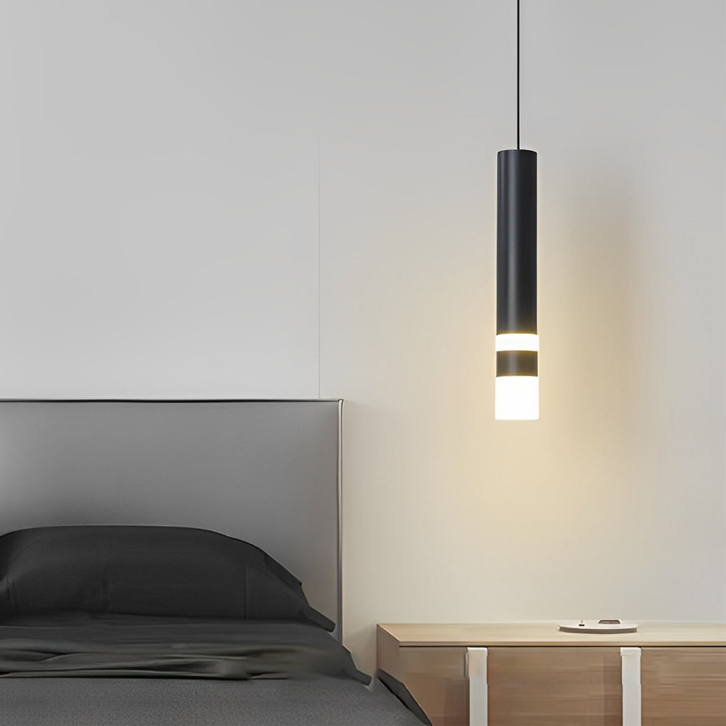 A single minimalist Black LED Cylinder Pendant light over a bedroom bedside nightstand setup.