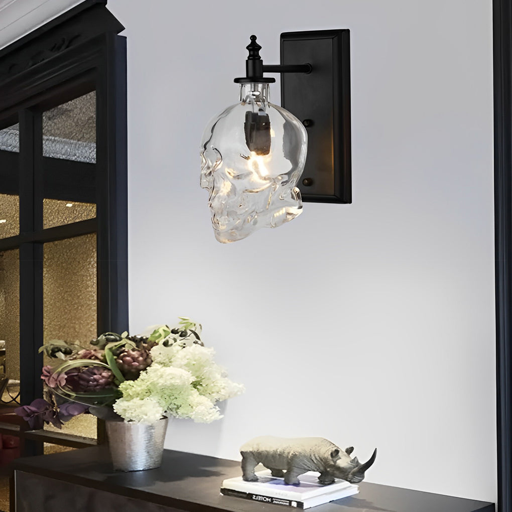 Stylish glass lamp shades for wall lights featuring a skull design, mounted indoors with decorative flowers on a side table.