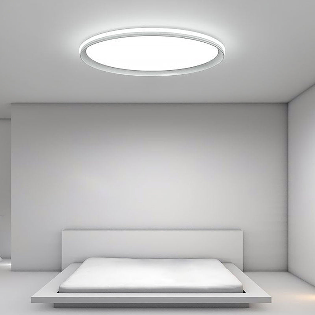 Slim ceiling light with cool white illumination in a minimalist bedroom.