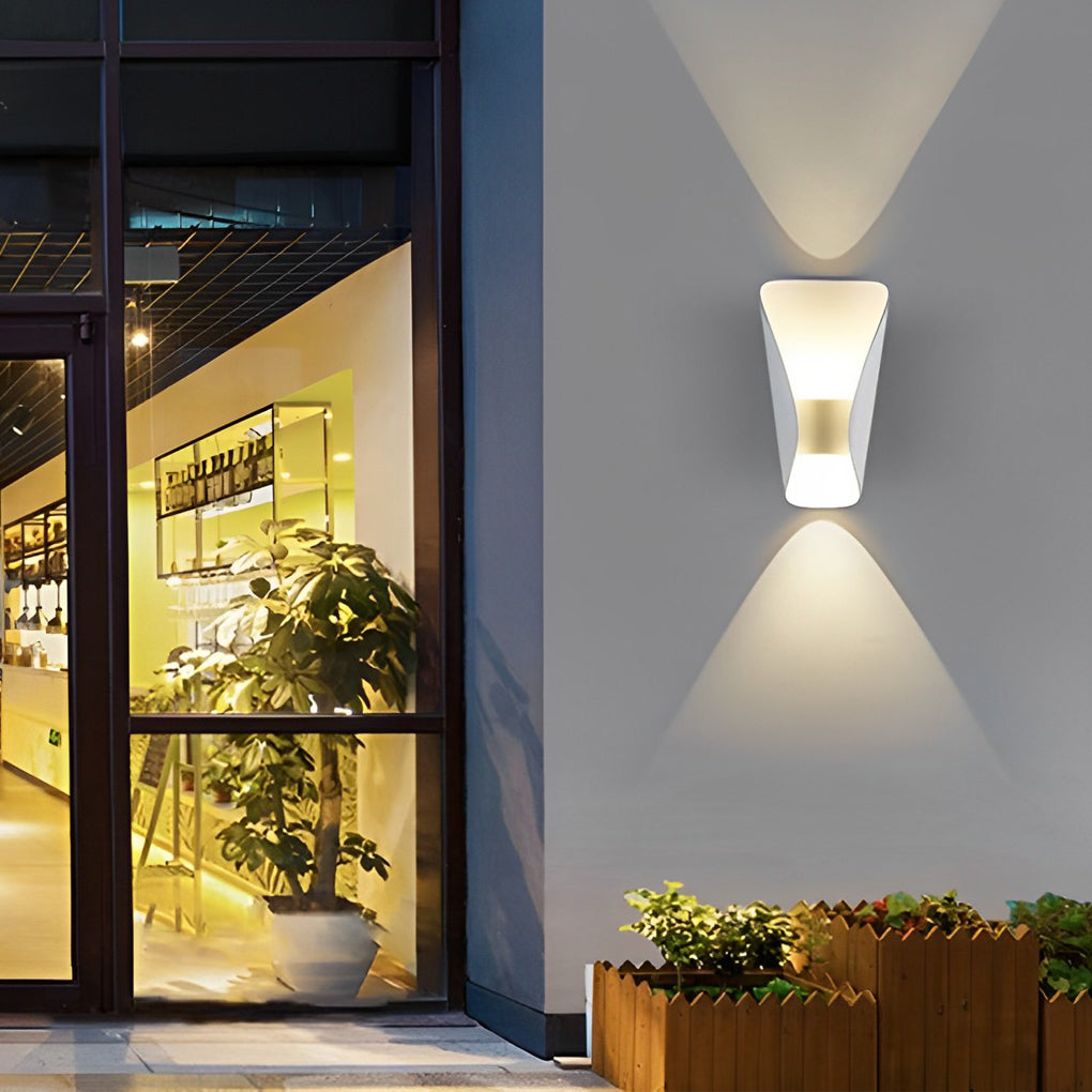 Small up down wall lights providing directional light beside a wooden fence.