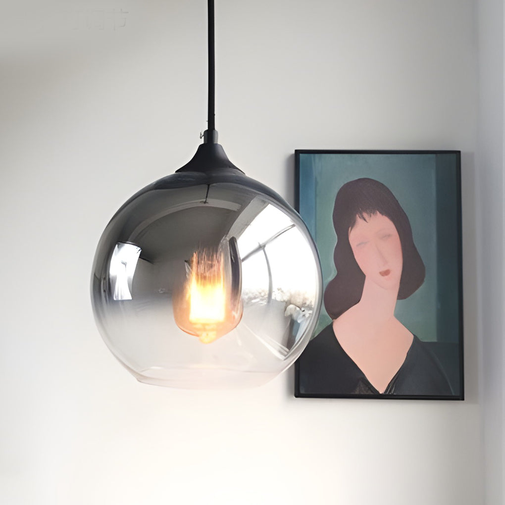 Sleek glass round pendant light with a smoky ombré finish and a warm glowing vintage bulb.