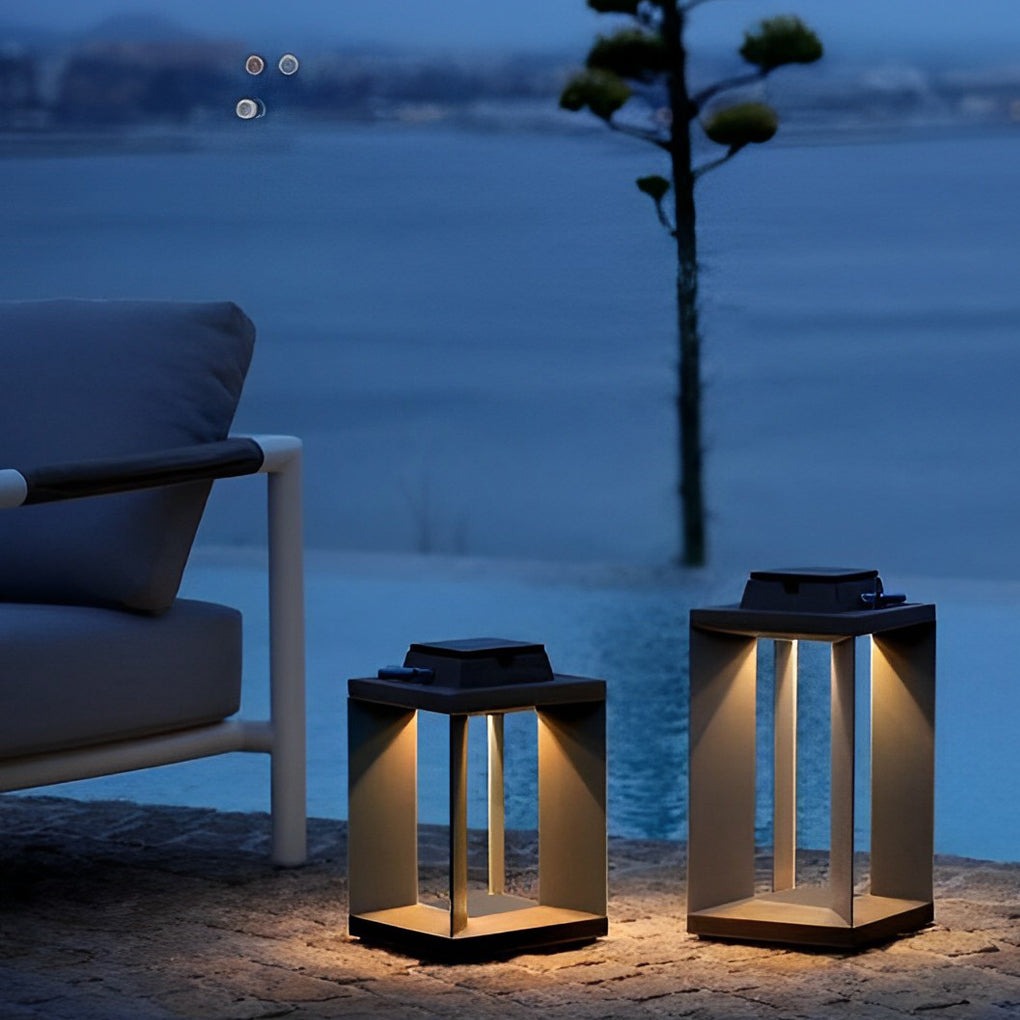 Solar powered lanterns placed on a terrace near outdoor chairs overlooking water at night.