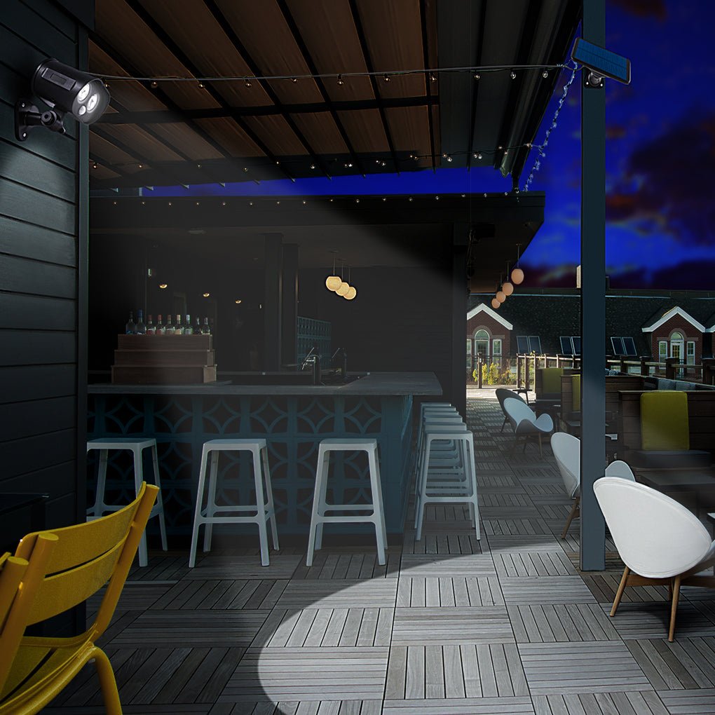 Backyard patio scene featuring a solar motion sensor lamp providing wide-angle illumination.
