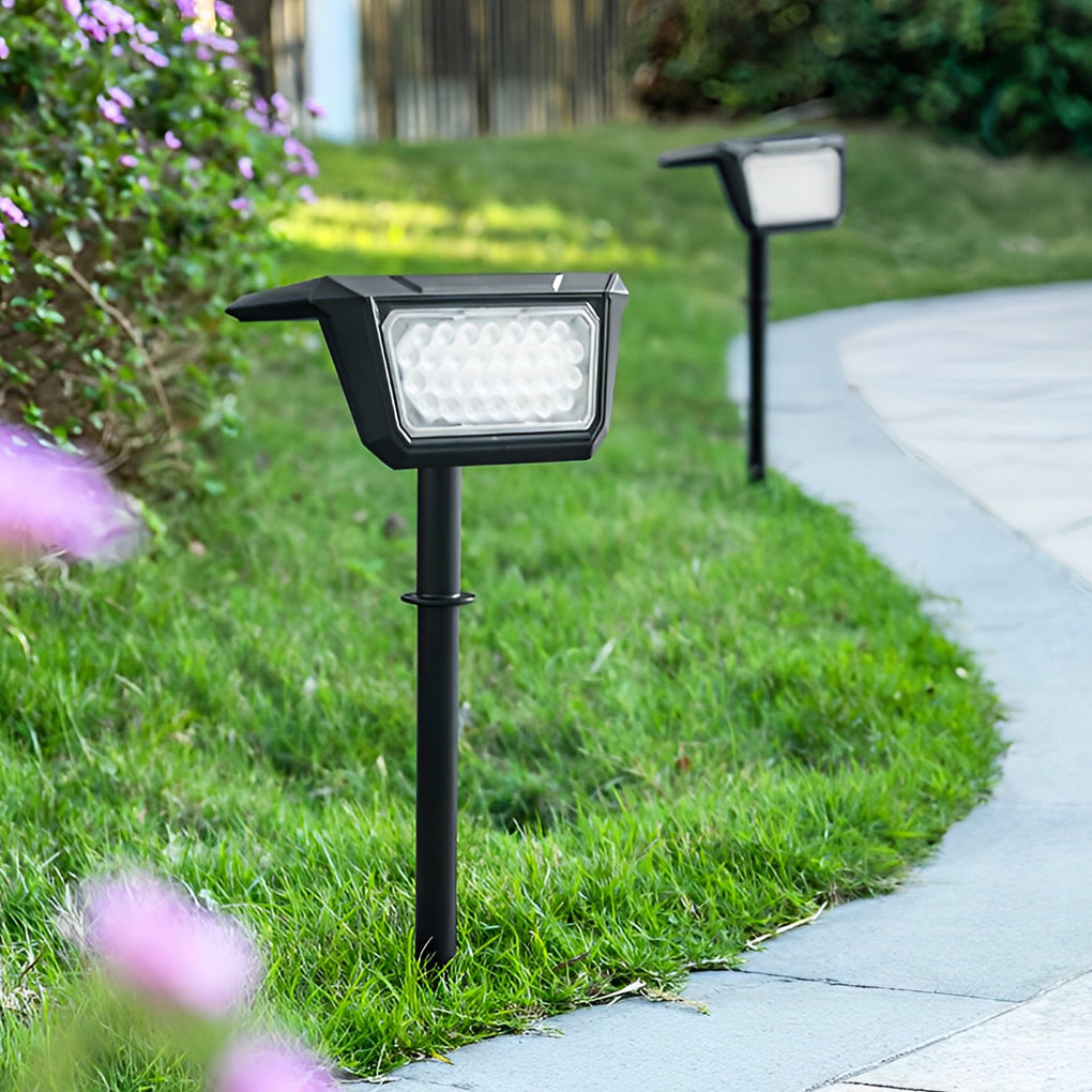 Solar path lights outdoor illuminating a flower bed, highlighting blooms and greenery in the evening.