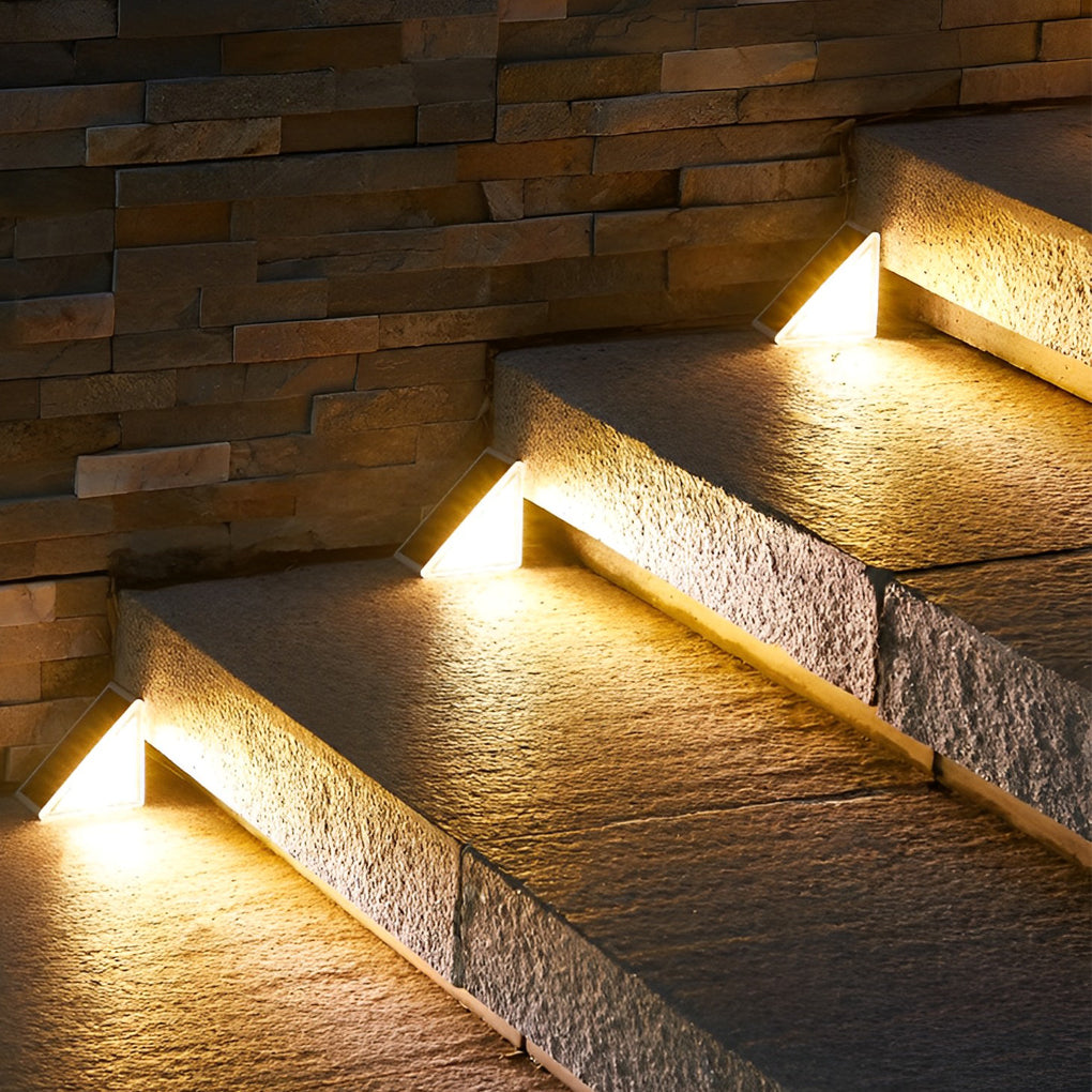Solar powered lights for steps with triangular design, emitting warm glow on outdoor stairs for nighttime navigation.