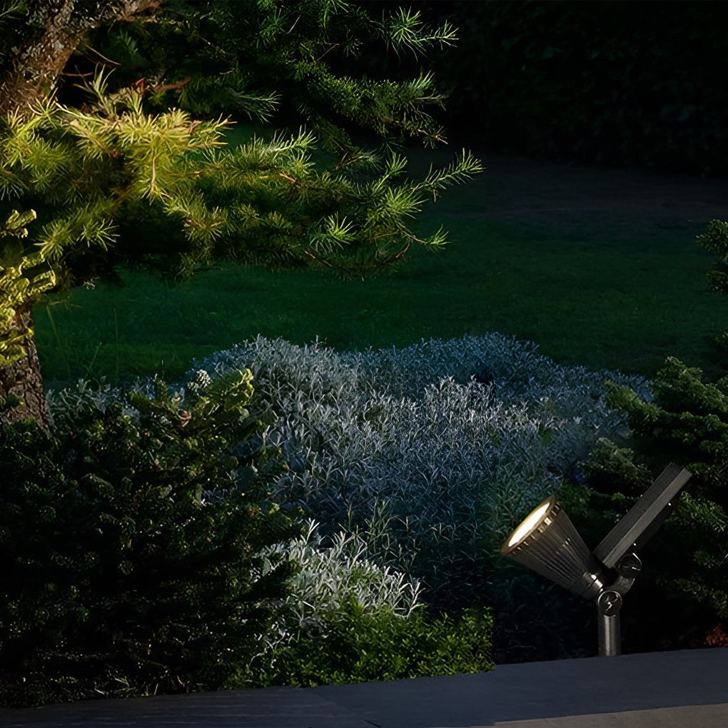 Solar powered spotlights aimed at shrubs and bushes, providing focused garden accent lighting at night.