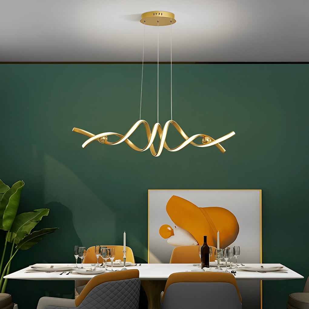 Gold spiral ceiling light above a dining table against a green wall.