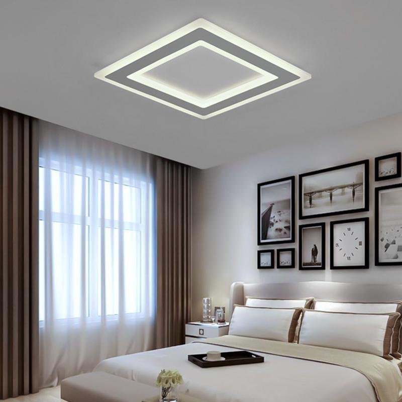 Square flush mount light providing ambient lighting in a modern bedroom.