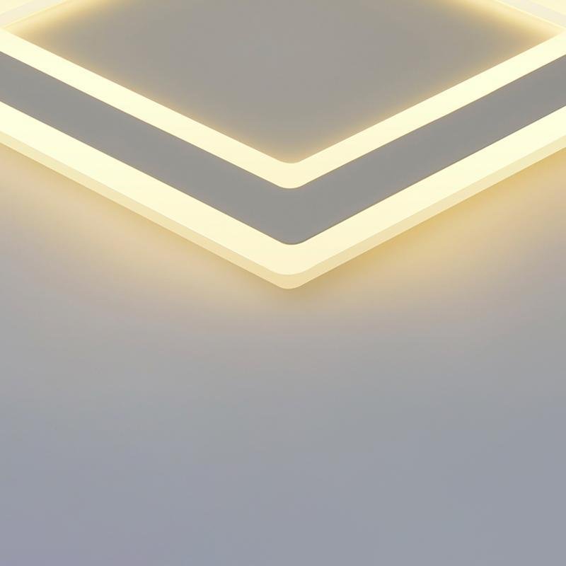 Square flush mount light with a minimalist design, illuminating a cozy bedroom.