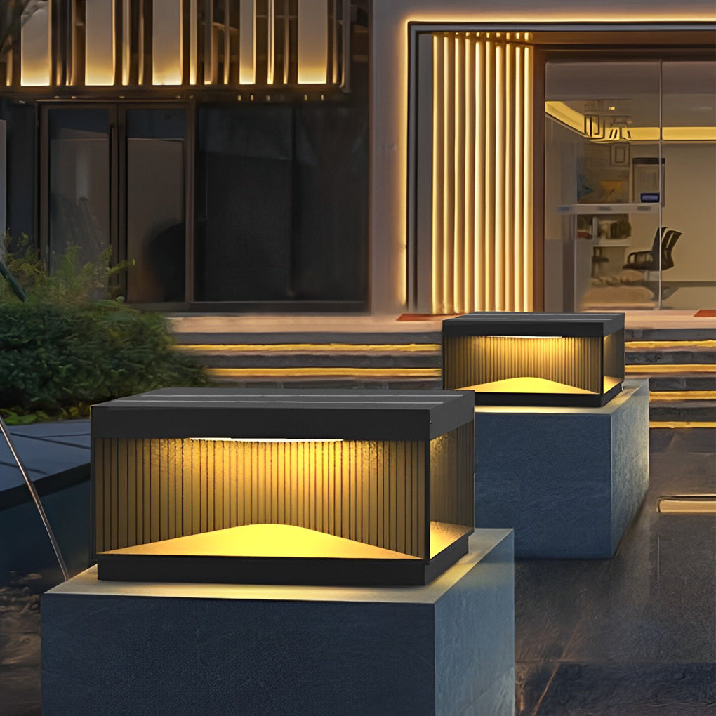 Modern square outdoor pillar lights mounted on entryway pillars creating elegant nighttime illumination.
